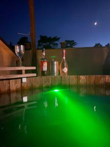 a pool of water with bottles and a wine glass at Domki Promyk in Mrzeżyno