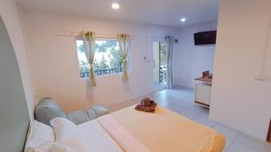 um quarto branco com uma cama e uma janela em เลคแค้มป์ รีสอร์ท em Kathun