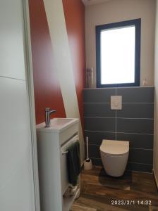 baño con aseo y lavabo y ventana en Proche Circuit, en Mulsanne