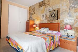 a bedroom with a bed and a lamp on a night stand at Un Oasis en Arrecife in Arrecife