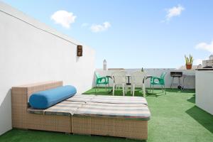 a balcony with a couch and a table and chairs at Un Oasis en Arrecife in Arrecife