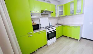 een groene keuken met gele kasten en een fornuis bij Comfortable apartment with a panoramic view in Chişinău