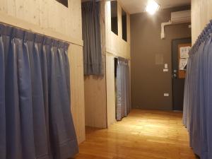 台北的住宿－Hostel of Rising Sun 昇行旅，一间设有蓝色窗帘和木地板的客房