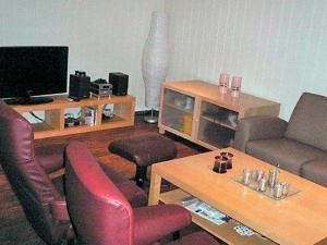 a living room with a couch and chairs and a tv at 10 person holiday home in Lindesnes in Spangereid