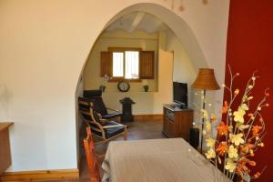 Beautiful 4-Bed House in Campo de Ricote في Collado de Gil: غرفة معيشة مع ممر وطاولة وكرسي