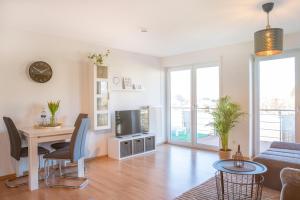 a living room with a table and a tv at FAIRflats: Küche, Balkon, Arbeitsplatz, Aufzug in Hüfingen
