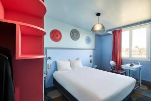 Cette chambre comprend un lit et un mur rouge et bleu. dans l'établissement B&B HOTEL Saint-Maur Créteil, à Saint-Maur-des-Fossés