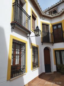 un edificio amarillo y blanco con ventanas y una puerta en Ático muy luminoso en el casco antiguo, en Córdoba
