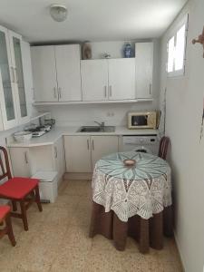 une petite cuisine avec une table et un four micro-ondes dans l'établissement Ático muy luminoso en el casco antiguo, à Cordoue