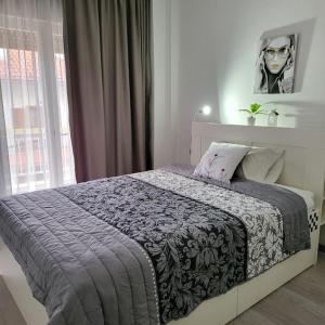 a bedroom with a bed with a black and white blanket at GREAT APARTMENT IN VERIA in Veria