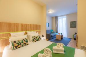 a bedroom with a large bed and a living room at Appart’City Confort Nantes Centre in Nantes