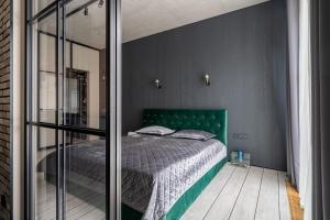 a bedroom with a bed with a green headboard at Lofts & Rosegold Luxury Stay in Elegant 1BR with Balcony in Riga Center in Rīga