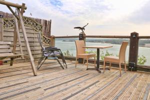 une terrasse avec des chaises, une table et un oiseau sur un poteau dans l'établissement Seaside Apartment, à Newquay