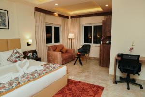 una camera d'albergo con letto, divano e scrivania di Regenta Inn Greater Noida, 15 Mins to India Expo Mart a Greater Noida