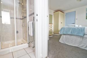 Cette chambre comprend un lit et une salle de bains pourvue d'une douche. dans l'établissement Seaside Apartment, à Newquay
