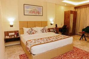 una camera d'albergo con letto e scrivania di Regenta Inn Greater Noida, 15 Mins to India Expo Mart a Greater Noida