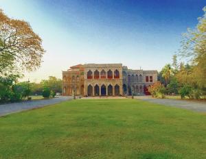 a large building with a large lawn in front of it at Nilambag Palace Hotel in Bhavnagar