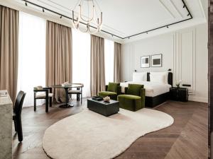 a bedroom with a bed and a living room with a table at The Amauris Vienna - Relais & Châteaux in Vienna