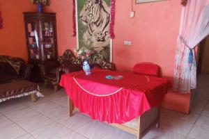 um quarto com uma mesa com uma toalha de mesa vermelha em EXPRESS O 92251 Jaya Kusuma Homestay em Jambi