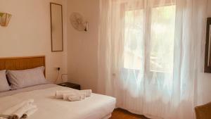 una camera da letto con un letto con lenzuola bianche e una finestra di Vacanza nella Natura a Punta Ala