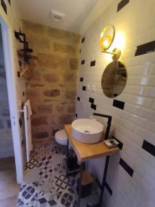 uma casa de banho com um lavatório e um WC em Le Pressoir chambres d'hôtes em Cardaillac
