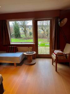 a living room with two windows and a table at Quiet villa apartment close to everything in Odense