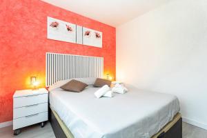 1 dormitorio con cama blanca y pared de color naranja en Romántico, acogedor y moderno., en Empuriabrava