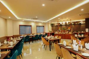 un ristorante con tavoli e sedie in legno e un bar di Regenta Inn Greater Noida, 15 Mins to India Expo Mart a Greater Noida