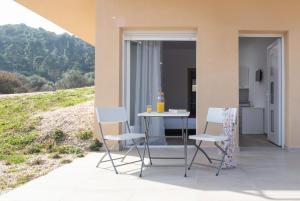 a table and chairs sitting on a patio at Les Oliviers - Studios & Apartments in Vourvourou