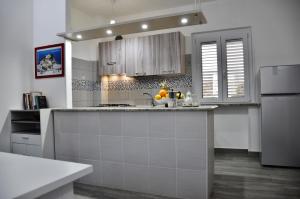 a kitchen with white cabinets and a counter top at Sapore di mare Home in Santa Domenica