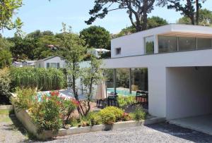 una casa blanca con un jardín delante de ella en ETXE LAUA, en San Juan de Luz