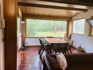 ein Wohnzimmer mit einem Tisch und Stühlen sowie einem großen Fenster in der Unterkunft Vacanza nella Natura in Punta Ala