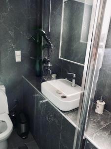 a bathroom with a sink and a toilet at Moxy Paxos in Makrátika