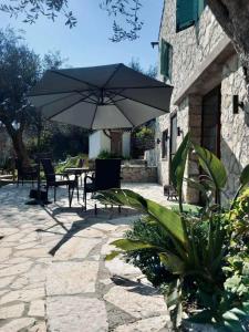 a patio with a table and an umbrella at Moxy Paxos in Makrátika