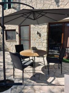 a table and chairs under an umbrella on a patio at Moxy Paxos in Makrátika