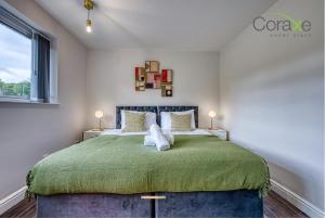 3 Bedroom Luxe Living for Contractors and Families by Coraxe Short Stays في دادلي: غرفة نوم بسرير كبير مع بطانية خضراء