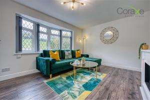 a living room with a green couch and a table at 3 Bedroom Luxe Living for Contractors and Families by Coraxe Short Stays in Dudley