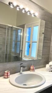 a bathroom sink with a large mirror above it at Aeginia 2 in Perdika