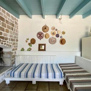 una panchina in una stanza con piatti appesi al muro di Casa Vacanze Capurre "Trulli e Pajare a due passi dal Pizzo" a Gallipoli