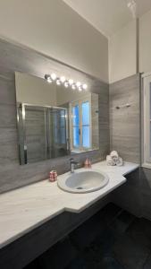 a bathroom with a sink and a large mirror at Aeginia 2 in Perdika