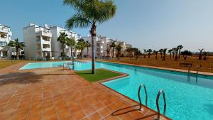 een zwembad met een palmboom en een aantal gebouwen bij Penthouse Arancha-Murcia Holiday Rentals Property in Roldán
