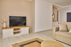 a living room with a television and a couch at Sea Front Zante Apartments in Zakynthos Town