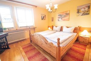ein Schlafzimmer mit einem Holzbett in einem Zimmer mit Fenstern in der Unterkunft Landhaus Müden in Faßberg