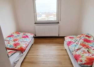 Duas camas num pequeno quarto com uma janela em City-Apartment Heidelberg em Eppelheim