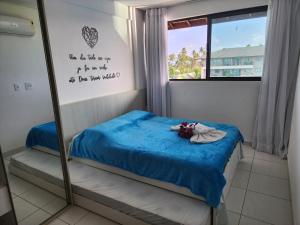 a small bedroom with a bed and a mirror at Boutique Ecolife in Porto De Galinhas