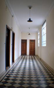 an empty hallway with doors and a checkered floor at Arrabal Porteño in Buenos Aires