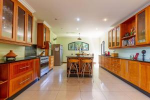 a large kitchen with wooden cabinets and a island with stools at Lovely Family home in Bryanston in Johannesburg