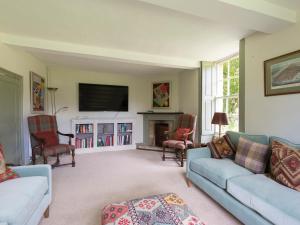 sala de estar con sofá y chimenea en Almsbury Farmhouse, en Winchcombe