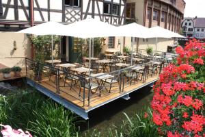 a deck with tables and chairs and an umbrella at Walk'sches Haus in Weingarten (Karlsruhe)