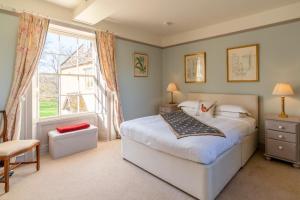 a bedroom with a bed and a large window at Almsbury Farmhouse in Winchcombe
